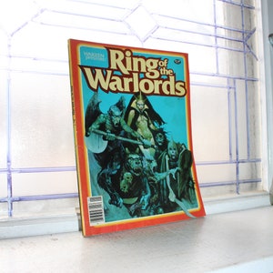 May include: A vintage comic book titled "Ring of the Warlords" by Warren Publishing. The cover features a fantasy illustration of a group of warriors and monsters in a blue and green landscape.