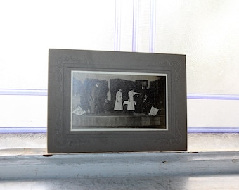 Fotografía de una escena de una obra de teatro en una tarjeta de gabinete antigua