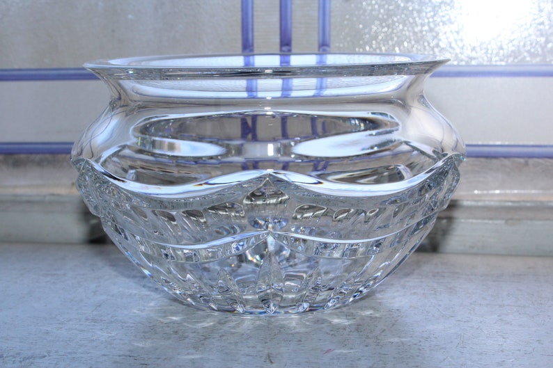 May include: A clear glass bowl with a cut crystal design. The bowl has a wide, round base and a slightly flared rim.