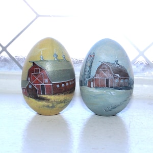 2 Uova di legno vintage dipinte a mano con scene di fattoria e fienile, firmate dall'artista.