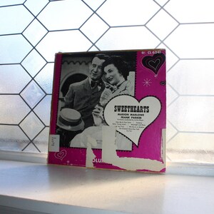 May include: A pink and white vinyl record album cover with a photo of a man and woman. The album is titled "Sweethearts" and features the names Marion Marlowe and Frank Parker. The album number is CL 6241.