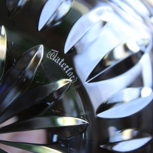 May include: Close-up of a Waterford crystal bowl with a detailed, intricate pattern. The word "Waterford" is etched into the bottom of the bowl.