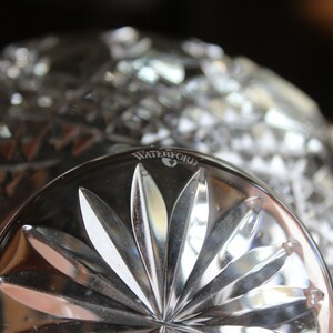 Puede incluir: Primer plano de un cuenco de cristal transparente con un dise&ntilde;o de estrella en la base. La palabra "WATERFORD" est&aacute; grabada en el borde. El cuenco tiene un patr&oacute;n de corte de diamante.