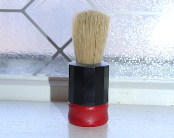 Pennello da barba vintage di metà secolo con manico in legno rosso e plastica nera.