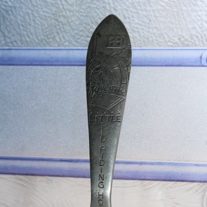 May include: A silver spoon with a design of Little Red Riding Hood and the words "Little Red Riding Hood" engraved on the handle.