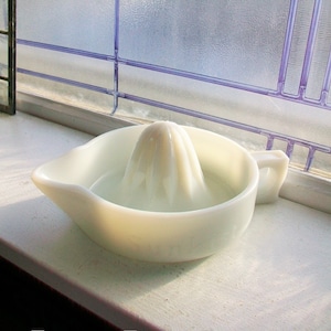 May include: White ceramic citrus juicer with a ridged center cone. The juicer is designed to squeeze lemons, limes, and oranges.