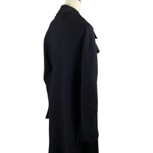 May include: A long, dark navy blue coat with a notched lapel and a contrasting black collar. The coat has a tailored fit and a classic design, suitable for various occasions.