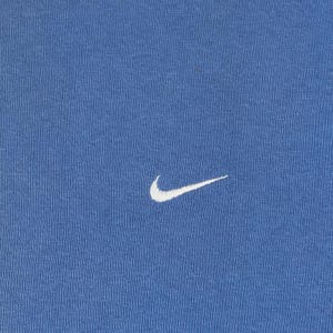 以下が含まれることがあります： 黒い持ち手と「But First, Coffee」のテキストが黒い太字で書かれた白いセラミックマグ。マグカップはぼやけた背景に置かれており、居心地の良い環境を示唆しています。