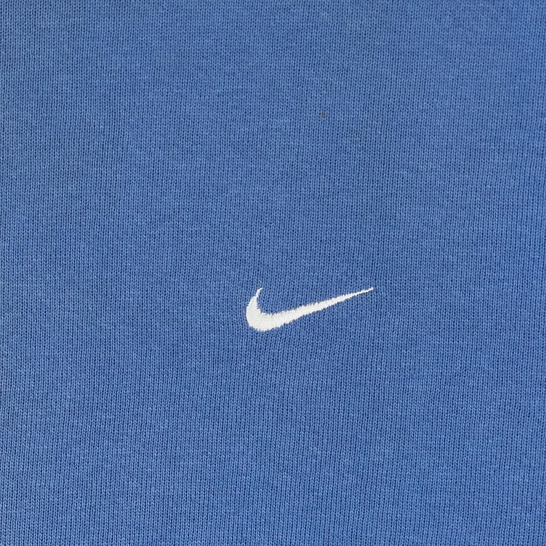 以下が含まれることがあります： 黒い持ち手と「But First, Coffee」のテキストが黒い太字で書かれた白いセラミックマグ。マグカップはぼやけた背景に置かれており、居心地の良い環境を示唆しています。