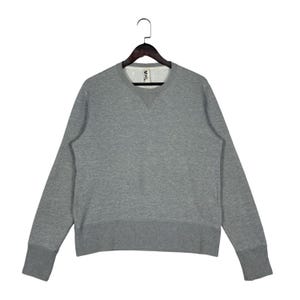 May include: A heather gray long-sleeve sweatshirt featuring a crew neckline with a triangular ribbed insert below the collar. The garment includes a wide ribbed hem and cuffs, and a white interior neck label with the black text MHL.