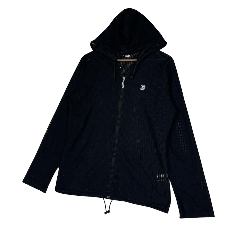 Pu&ograve; includere: Giacca nera con cappuccio e zip con un piccolo logo sul petto. La giacca ha un cordoncino in vita e un cappuccio foderato in rete. Le maniche lunghe hanno un design a rete. Un capo di abbigliamento esterno casual.