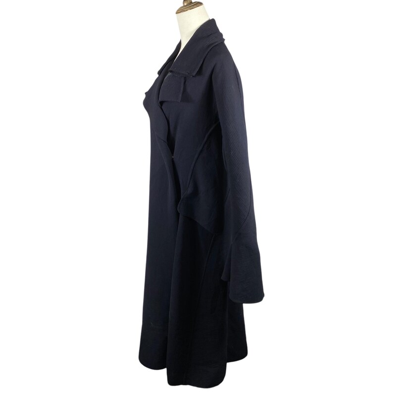 May include: A long, dark navy coat with a tailored design. The coat features a wide lapel, a wrap-style closure, and a flared skirt. The sleeves are long, and the coat appears to be made of a heavy fabric. The coat is displayed on a mannequin.
