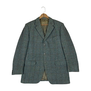 May include: A teal and brown plaid blazer with a three-button closure, two front pockets, and a notched lapel. The jacket is hanging on a wooden hanger. The blazer has a classic, tailored fit.