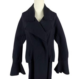 May include: A dark navy blue jacket with a unique design. The jacket features a wide lapel, a double-breasted closure, and flared sleeves. The garment is displayed on a mannequin against a white background.