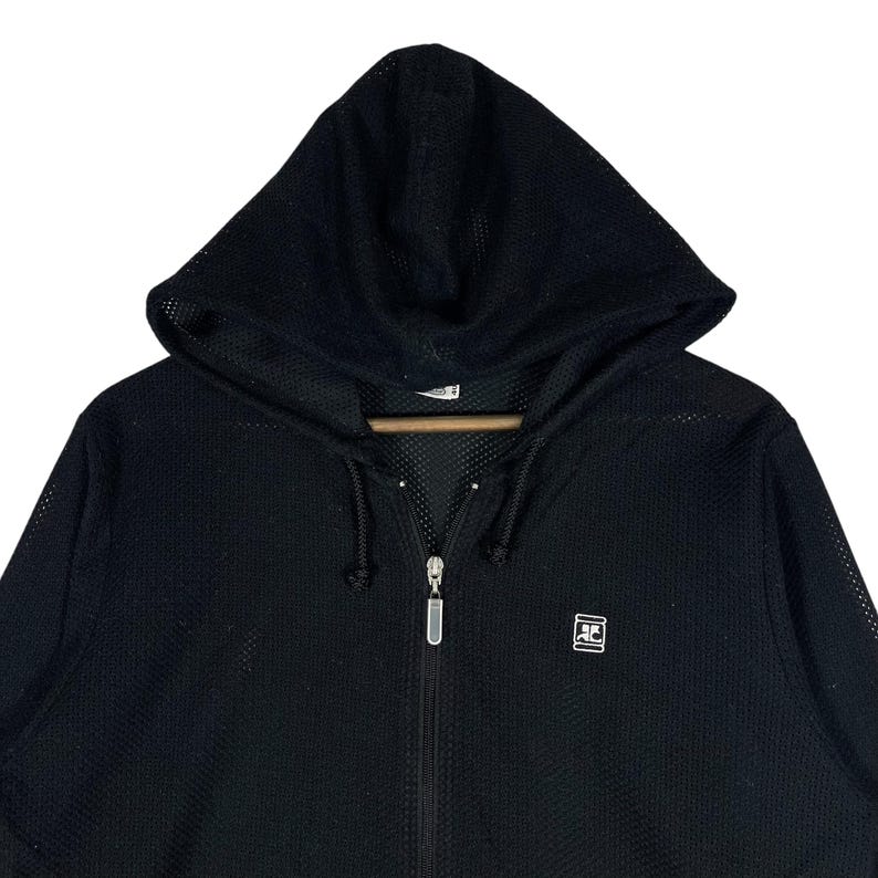 Pu&ograve; includere: Felpa con cappuccio nera con cerniera e texture a rete. La felpa con cappuccio ha un cordoncino, un cappuccio e un piccolo logo sul petto. La cerniera &egrave; color argento.