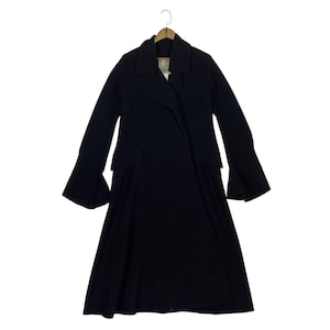 May include: A long, black coat with a flared skirt and wide sleeves. The coat has a double-breasted design with a notched collar and is hanging on a wooden hanger.