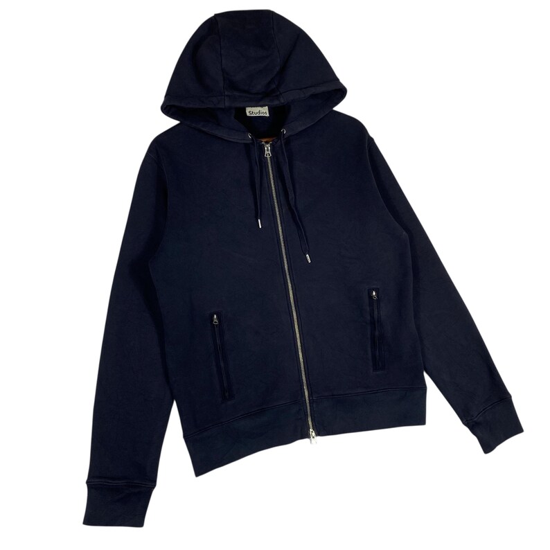 May include: Navy blue zip-up hoodie with a drawstring hood and two front pockets. The hoodie has a silver zipper and a small label near the hood. A casual outerwear garment.