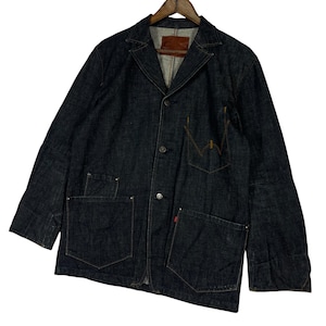 Puede incluir: Chaqueta vaquera azul oscuro con dise&ntilde;o de blazer cl&aacute;sico. Cuenta con tres bolsillos delanteros, un bolsillo en el pecho y cierre de botones. La chaqueta tiene un parche de cuero marr&oacute;n en el interior del cuello y una etiqueta roja en el bolsillo.