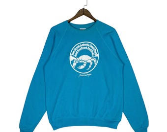 Bluza z nadrukiem Hanes Astoria Crab Feed & Seafood Festival z lat 80. w stylu vintage | Niebieski sweter typu raglan | Wyprodukowano w USA | Rozmiar L