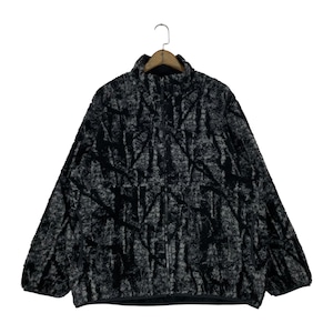 Peut inclure: Une veste polaire zippée noire et grise avec un col montant et un motif abstrait texturé sur l'ensemble. Le vêtement comprend une fermeture éclair frontale intégrale, des manches longues avec poignets élastiqués et un ourlet droit.