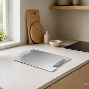 Peut inclure: Un plateau de service rectangulaire en métal argenté doté de deux poignées intégrées sur les côtés opposés. Le plateau présente une finition brossée lisse et une surface plane, conçue pour transporter ou présenter des objets dans une cuisine.