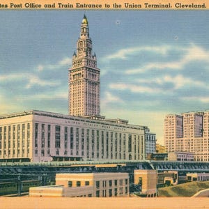 May include: Vintage postcard featuring the United States Post Office and Train Entrance to the Union Terminal in Cleveland, Ohio. The image shows a large building with a tall tower, a train overpass, and other buildings under a blue sky.