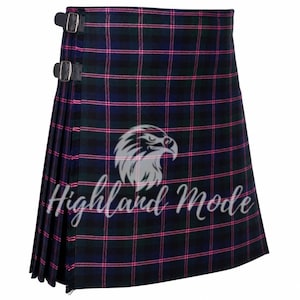 Könnte beinhalten: Ein Schottenkilt in einem dunkelblauen, grünen und rosa Karomuster. Der Kilt hat zwei Lederriemen mit Schnallen und den Text "Highland Mode" mit einem Adlerlogo. Der Kilt ist plissiert und hat ein traditionelles Design.