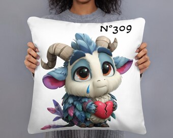 May include: White decorative pillow featuring a cartoon creature with large brown eyes, blue and purple feathers, and a broken heart. The pillow has the text "N°309" in black.