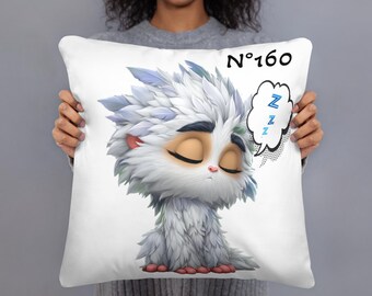 May include: White decorative pillow featuring a cartoon illustration of a sleeping, fluffy creature with closed eyes. The pillow has the text "N°160" and a speech bubble with "Z"s.
