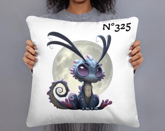 May include: White square pillow featuring a cartoon dragon with large purple eyes, blue scales, and pink accents. The dragon is set against a full moon backdrop. The text "N°325" is printed in black on the pillow.