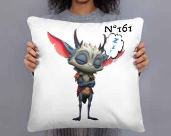 May include: White pillow featuring a cartoon creature with closed eyes, crossed arms, and a thought bubble with "Z"s. The creature has blue, red, and white coloring. The pillow has the text "N°161" in black.