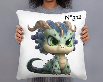 May include: White decorative pillow featuring a cartoon dragon with green and blue scales, large green eyes, and small horns. The pillow has the text "N°312" in black.