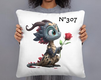 May include: White throw pillow featuring a cartoon dragon holding a red rose. The dragon has blue, tan, and red accents. The pillow has the number "307" printed in black.