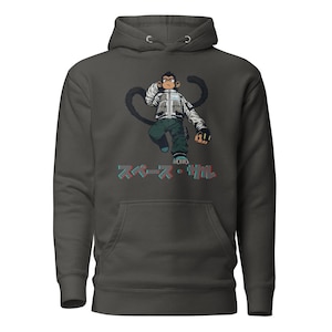 May include: Dark gray hoodie featuring a cartoon monkey character in a white jacket, green pants, and black gloves. The monkey has a long, curved tail. Japanese text in red and blue is below the monkey. The hoodie has a front pocket and a hood.