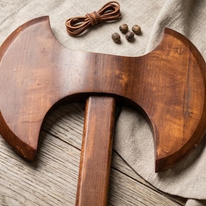 May include: A white ceramic mug with a black handle and the text "But First, Coffee" in a black, bold font. The mug is on a white surface.