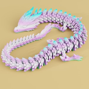 May include: A flexible, articulated dragon figurine featuring a gradient color scheme that transitions from soft pastel pink and white to vibrant turquoise accents along the spine and head, with a segmented, scale-like body design throughout.