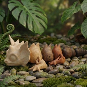 May include: A series of articulated wooden dragon figurines in varying shades of natural wood, ranging from light beige to dark brown. The figures feature carved scales and horns, with one segment displaying a small star icon and the word Etsy.