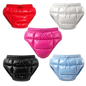 Può includere: Una collezione di cinque pantaloncini imbottiti trapuntati in rosso, bianco, rosa acceso, nero e azzurro. Ogni paio presenta un taglio sgambato, un elastico in vita con coulisse abbinata e una finitura in tessuto lucido e idrorepellente.