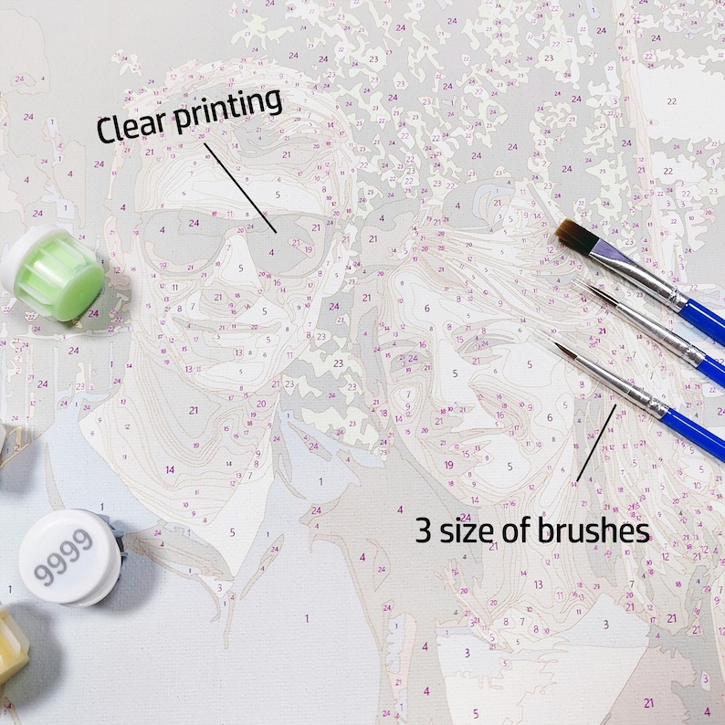 May include: A paint-by-numbers canvas featuring a line drawing of two faces with numbered sections, labeled with the text Clear printing. Included are three paint brushes with blue handles and several small round paint pots with white lids.