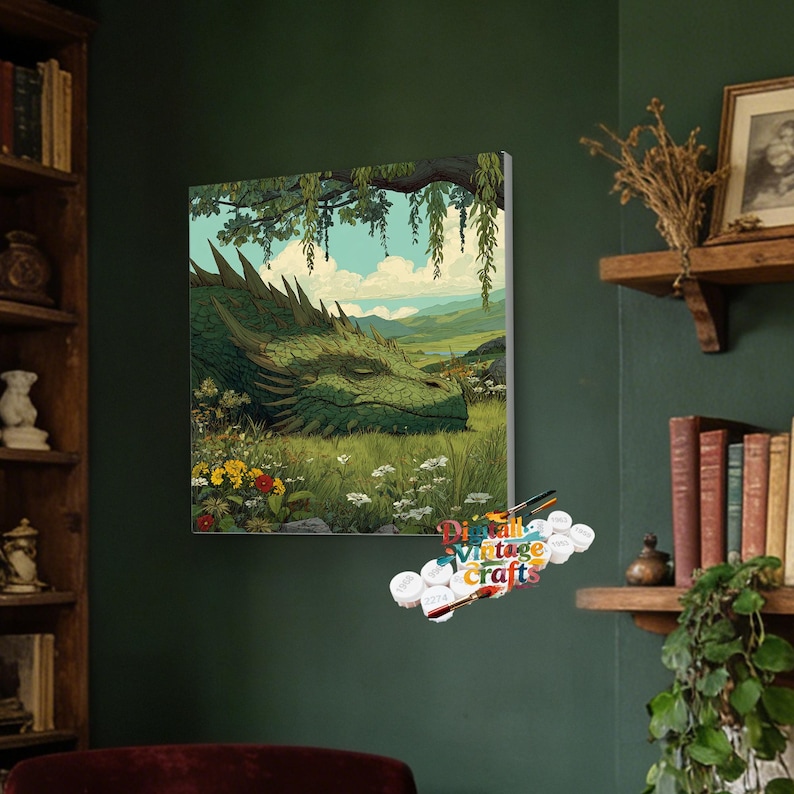 May include: A square paint-by-numbers canvas featuring a large green dragon resting in a grassy meadow with wildflowers under a tree, accompanied by a set of numbered paint pots and brushes labeled with the text Digital Vintage Crafts.