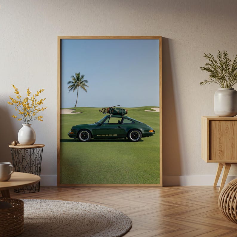 Puede incluir: Impresi&oacute;n enmarcada que muestra un coche deportivo Porsche verde oscuro en un campo de golf. El coche tiene un portaequipajes en el techo. El fondo incluye una palmera, cielo azul y un campo de golf verde.