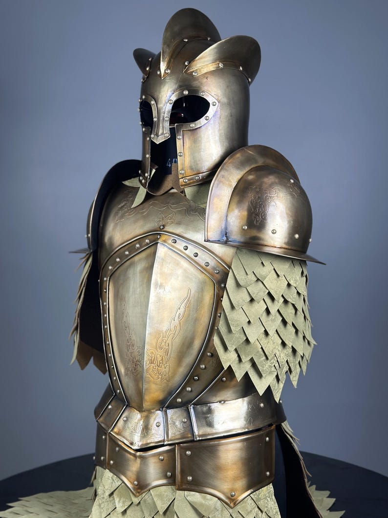 May include: A detailed bronze-colored suit of armor, featuring a helmet with a distinctive crest and eye openings. The breastplate and shoulder guards are adorned with etched designs and rivets. The armor includes layered, scale-like elements.