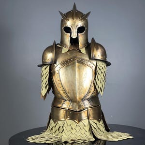 May include: A detailed bronze-colored suit of armor, including a helmet with spikes, shoulder guards, and chest plate. The armor has intricate detailing and a layered design on the shoulders and lower torso, suggesting a historical or fantasy theme.