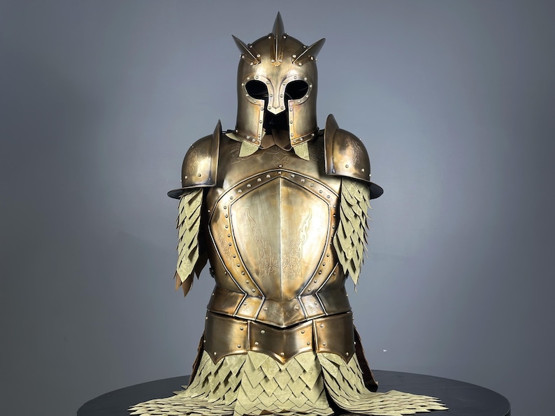 May include: A bronze-colored suit of armor, featuring a helmet with pointed accents and a visor. The chest plate and shoulder guards are detailed with rivets. The armor includes layered, scale-like elements around the shoulders and waist, creating a medieval aesthetic.