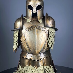 May include: A full suit of antique gold-colored armor, including a helmet with spikes, shoulder guards, and a chest plate. The armor has riveted details and a scale-like skirt. The overall design suggests a medieval or fantasy theme.