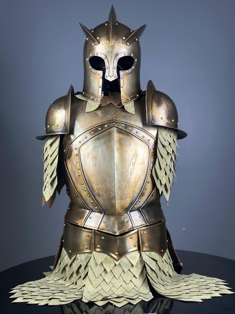 May include: A full suit of antique gold-colored armor, including a helmet with spikes, shoulder guards, and a chest plate. The armor has riveted details and a scale-like skirt. The overall design suggests a medieval or fantasy theme.