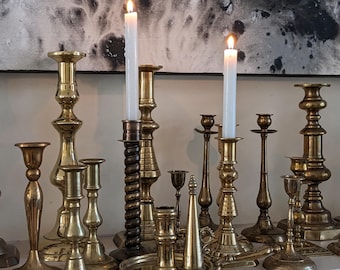 Candelabros antiguos de latón, varios estilos y tamaños.