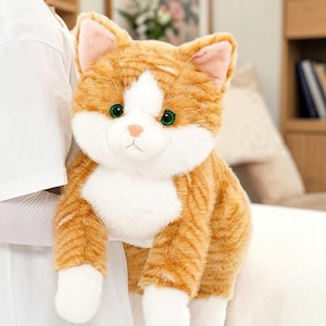 Könnte beinhalten: Ein Set aus drei Keramikbechern mit gesprenkelter, matter Oberfläche. Die Becher sind in Creme-, Hellgrau- und Dunkelgrautönen gehalten. Jeder Becher hat ein schlichtes, minimalistisches Design und einen abgerundeten Henkel. Geeignet für Kaffee, Tee oder andere Getränke.