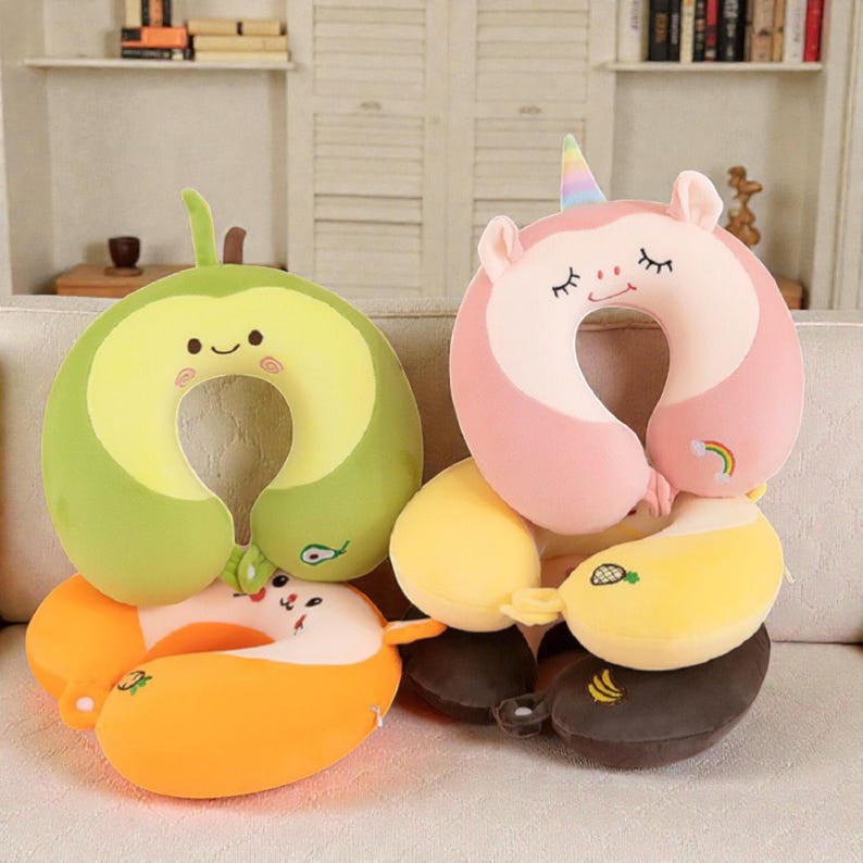 Pode incluir: Uma cole&ccedil;&atilde;o de almofadas de pesco&ccedil;o de viagem em v&aacute;rios designs de frutas e animais. As almofadas incluem um abacate, um unic&oacute;rnio e duas almofadas em forma de banana. As almofadas s&atilde;o em tons de verde, rosa, amarelo e laranja.