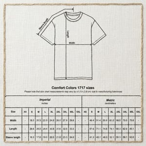 Puede incluir: Un diagrama de una camiseta con medidas de ancho, largo y largo de manga. La tabla incluye medidas de tallas en pulgadas y cent&iacute;metros para tallas Comfort Colors 1717, que van desde XS hasta 5XL.